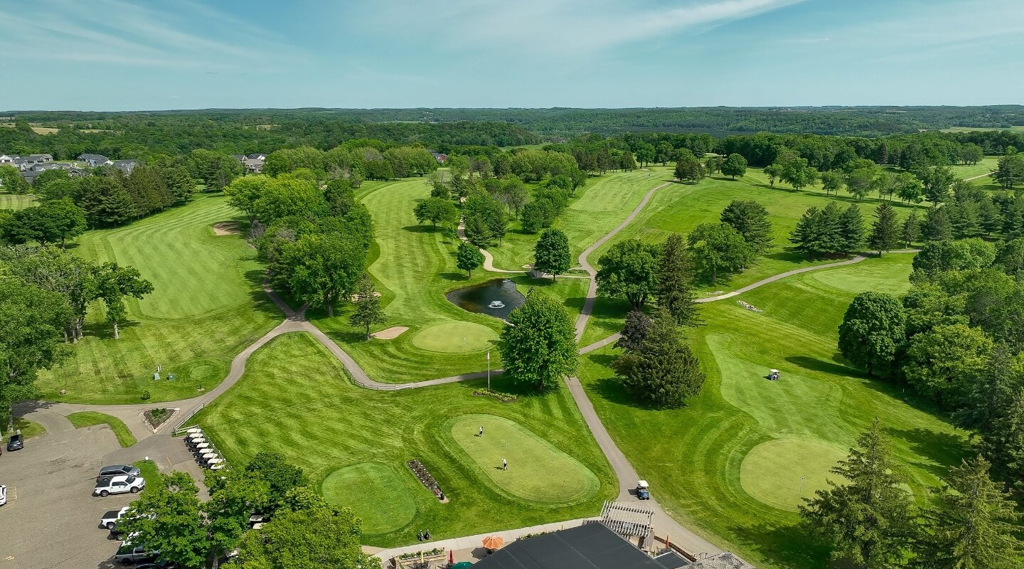 aerial view of river falls golf course surrounded by trees and rolling hills