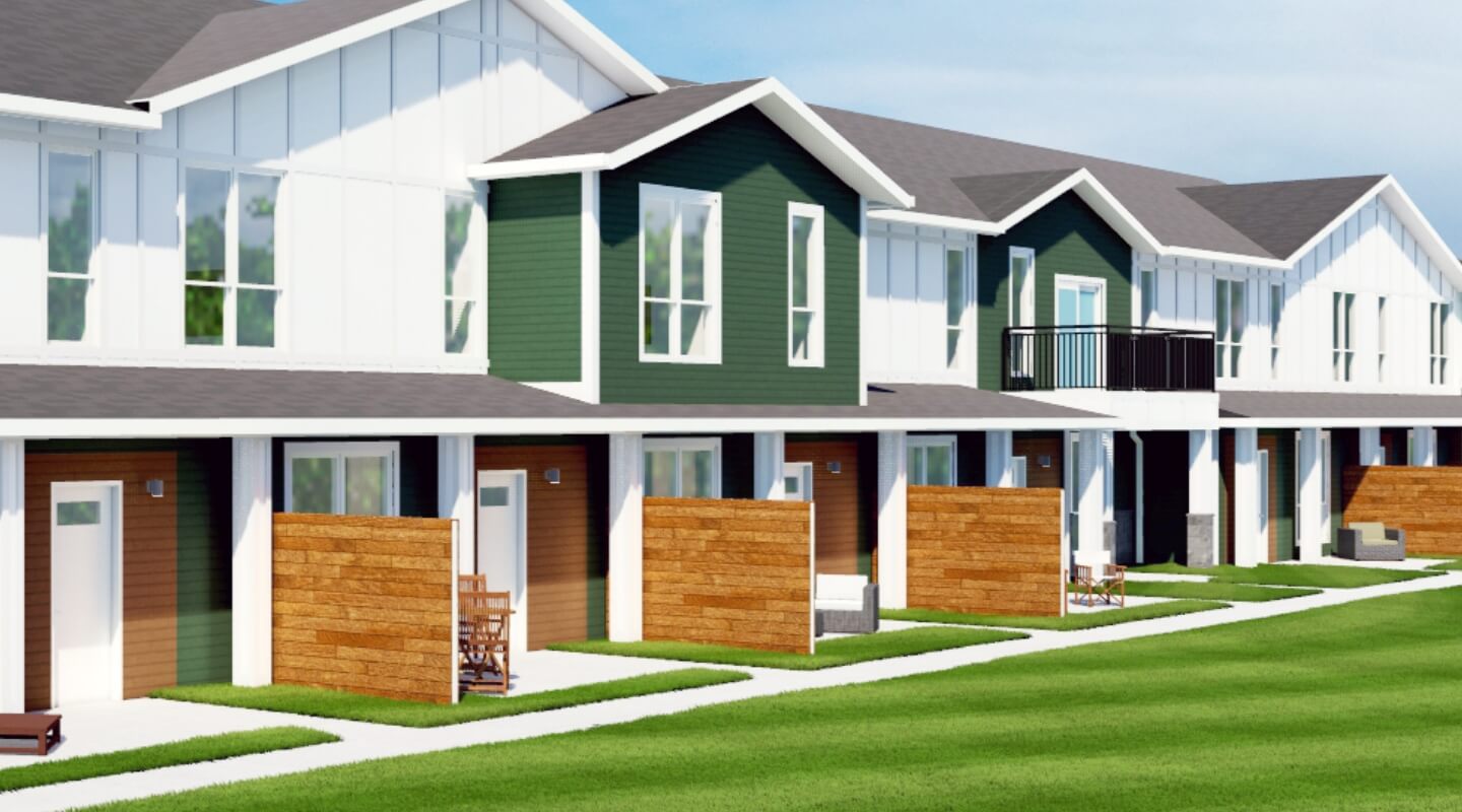Exterior view of green and white Brookgreen Townhomes with private patios and upper balconies