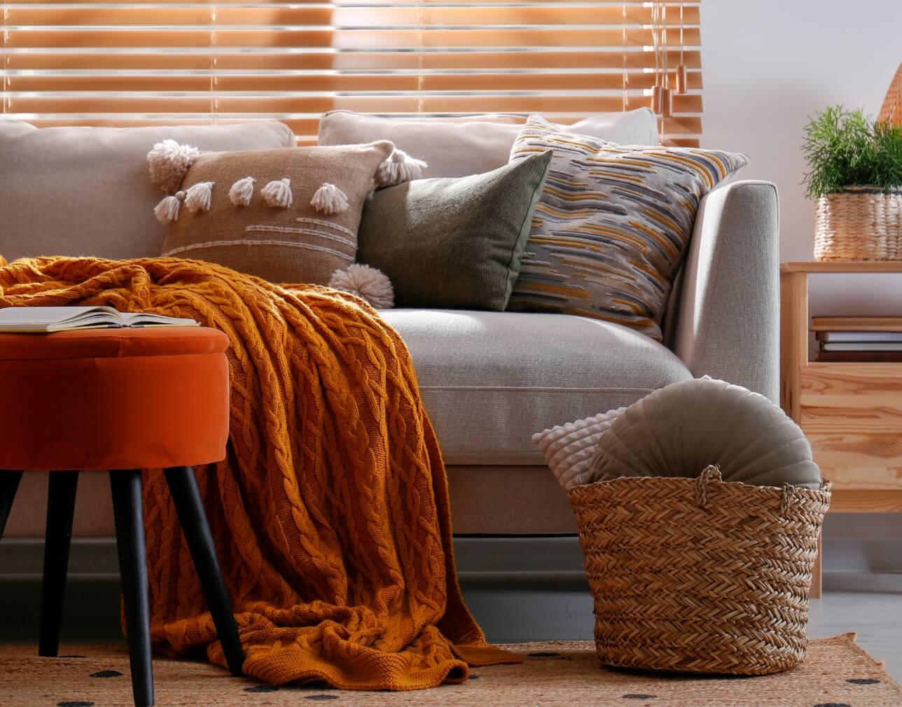 cozy living room with sofa, decorative pillows, throw blanket, and woven basket