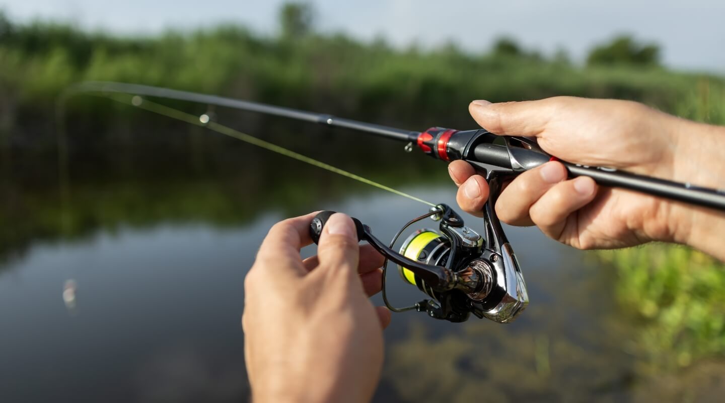 close up of person fishing on kinnickinnic river with rod and reel