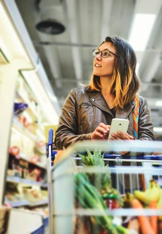 woman grocery shopping with cart at a local store in river falls