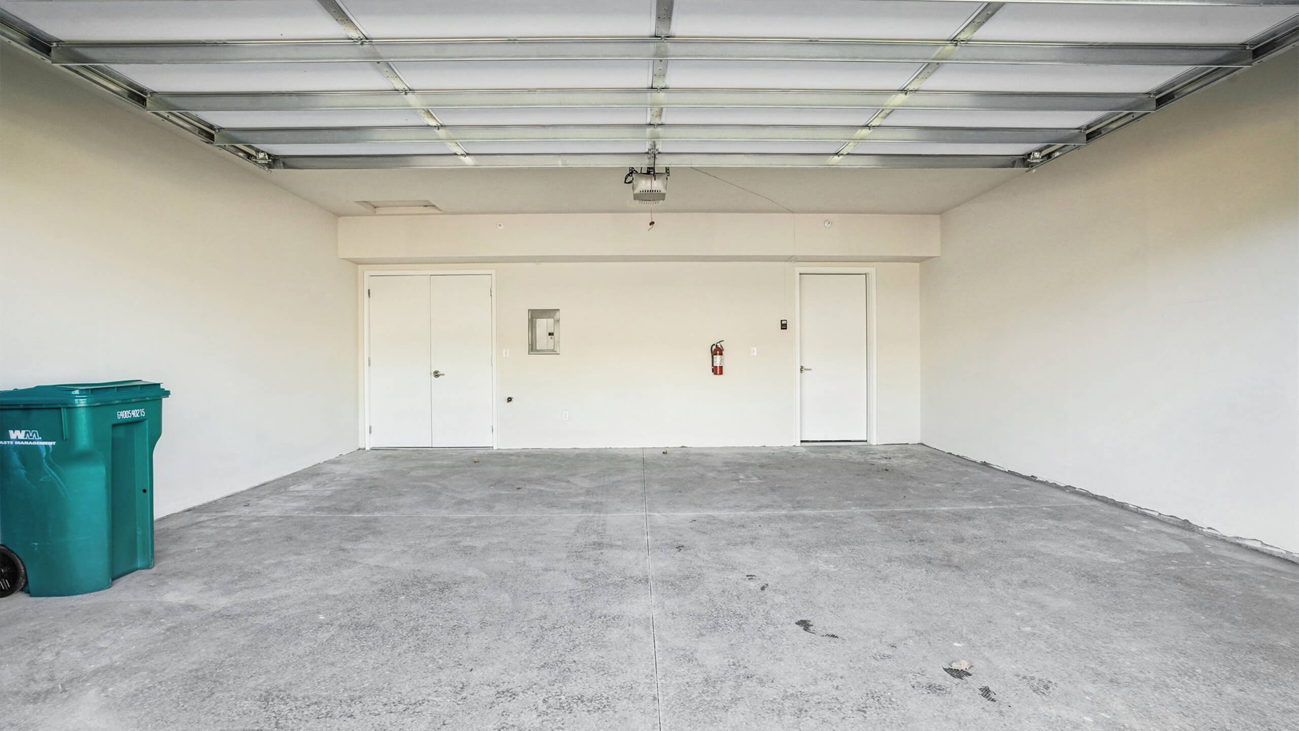 Clean two-car garage with white walls, overhead door, and concrete floor.